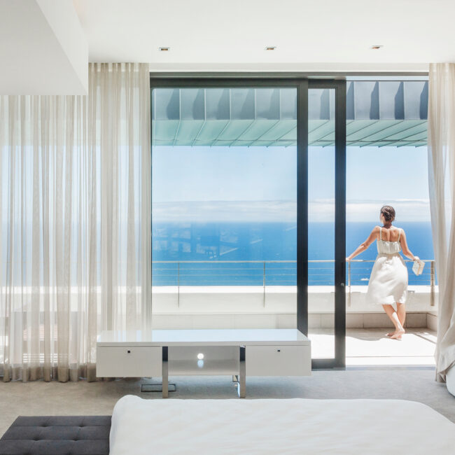 Woman on modern balcony overlooking ocean